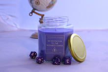 Load image into Gallery viewer, The medium sized 16oz jar of the Wayside Wizard&#39;s themed dnd candle - An invitation to the Wizard&#39;s tower. A globe sits unfocused in the background and dice are scattered on the tabletop. The label reads &#39;The Wayside Wizard&#39;, then &#39;An Invitation to the Wizard&#39;s Tower&#39; and in small text it says &#39;hand-poured soywax candles&#39;
